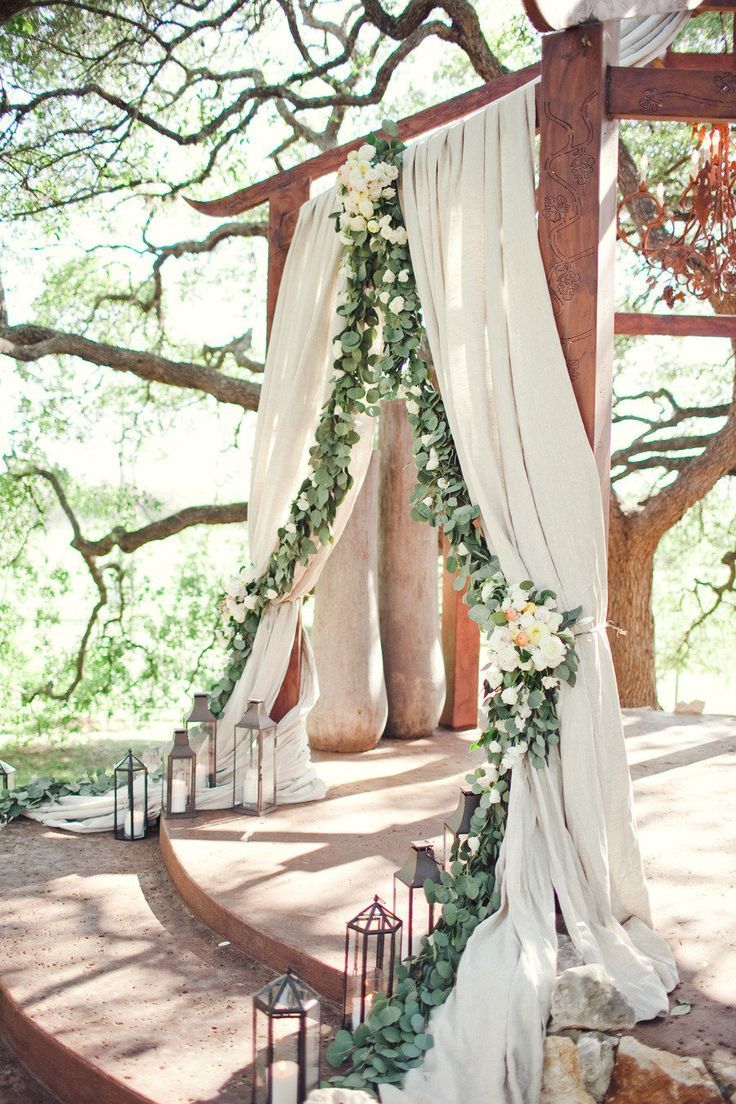 The ceremony site will feature a garland of eucalyptus and bay laurel swagging back with the curve of the taupe colored fabric curtains. Clusters of white hydrangeas, Juliet garden roses, ivory spray roses and blush spray roses will be in the top, middle and on the sides of the design.